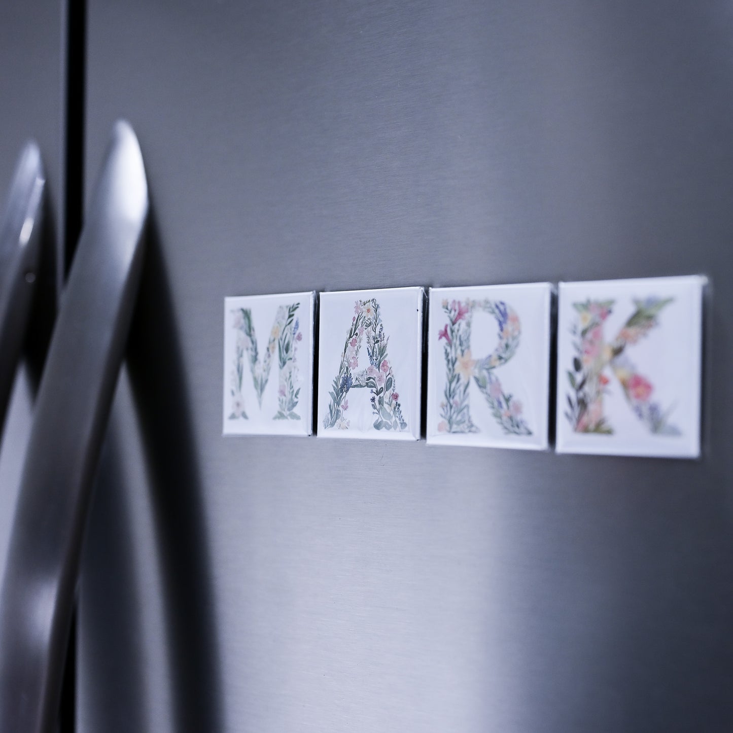 Decorative name magnets spelling 'MARK' on a refrigerator door.