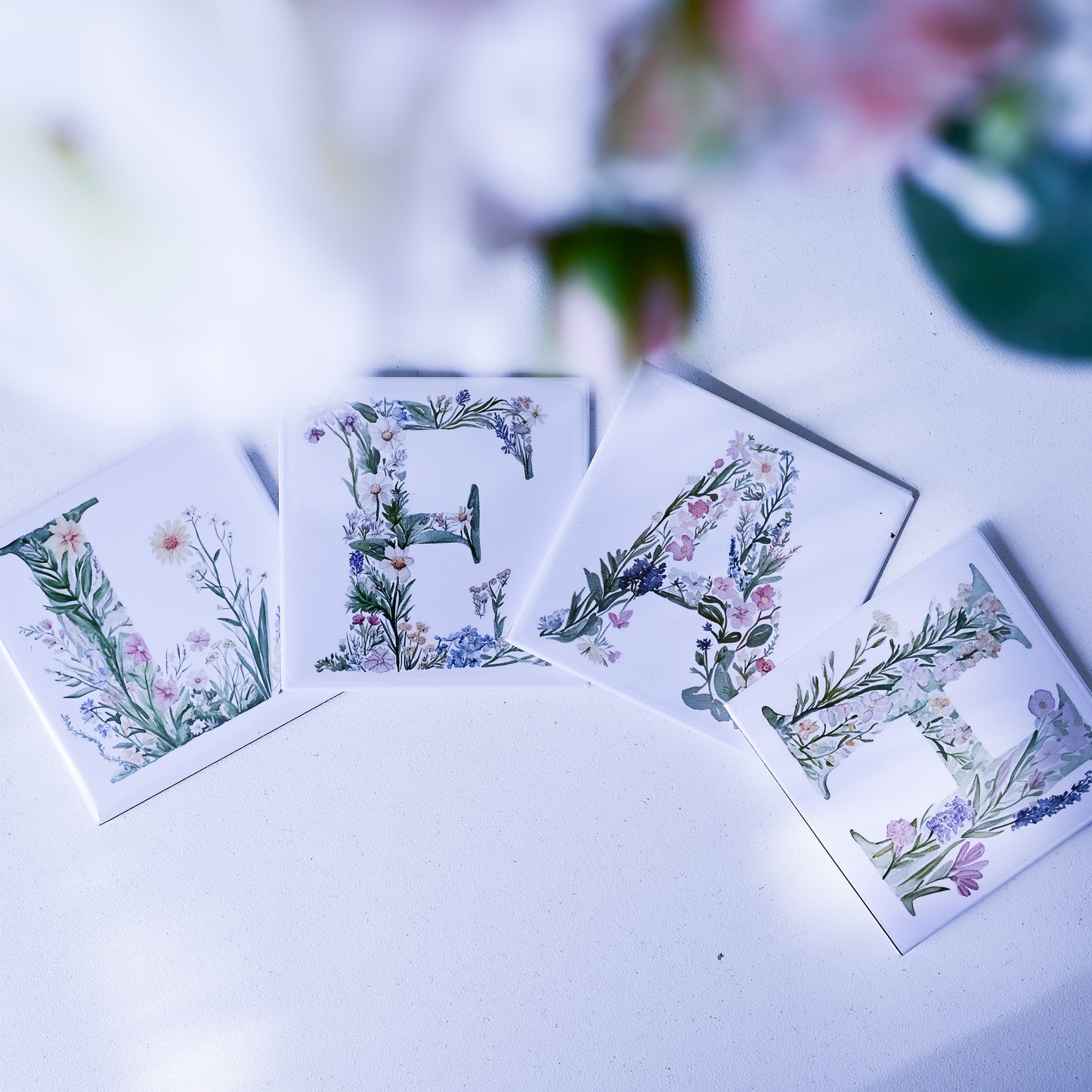 Floral alphabet magnets spelling 'Leah' on a white surface with blurred background