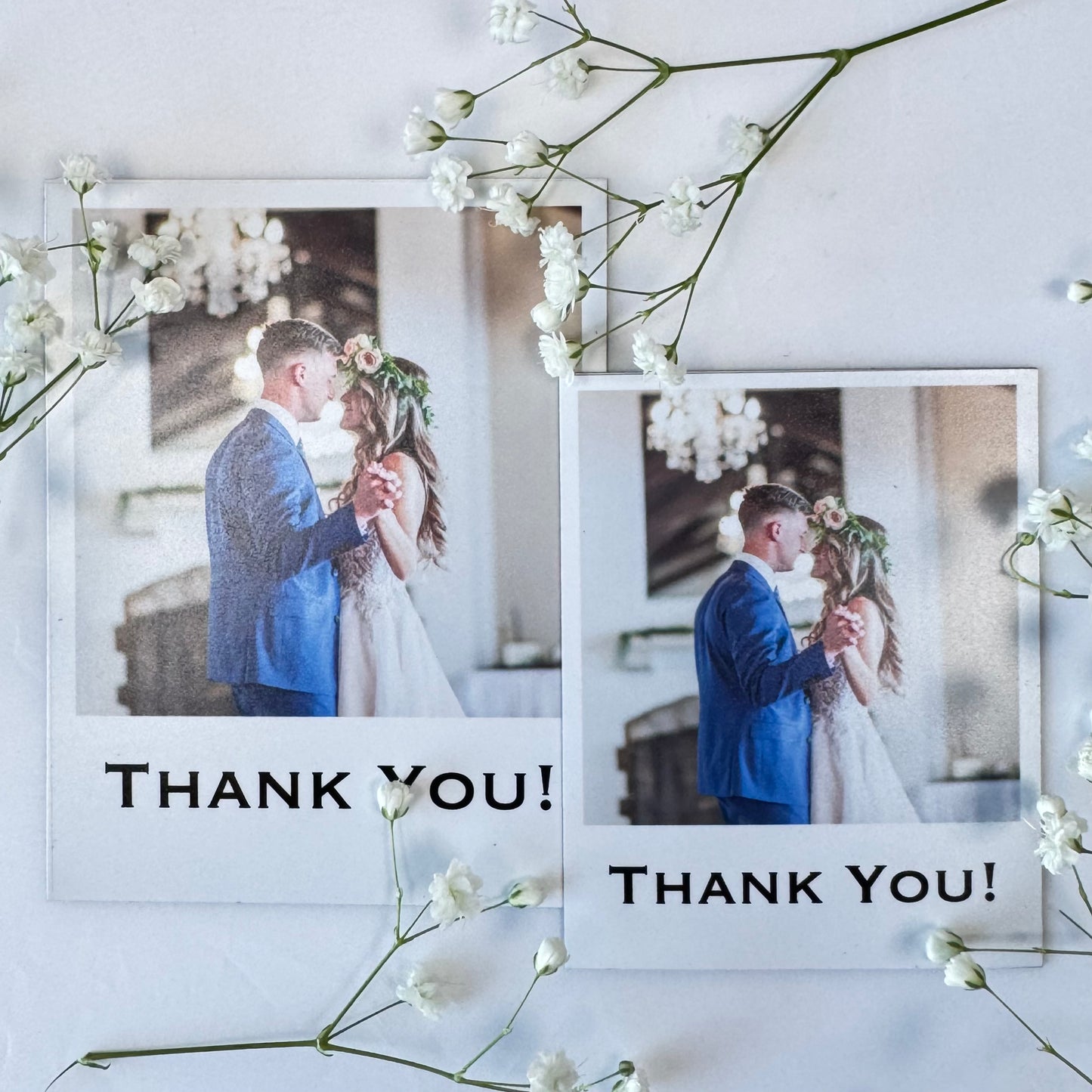 Two wedding photo magnets with 'Thank You!' text, surrounded by white flowers on a light background.