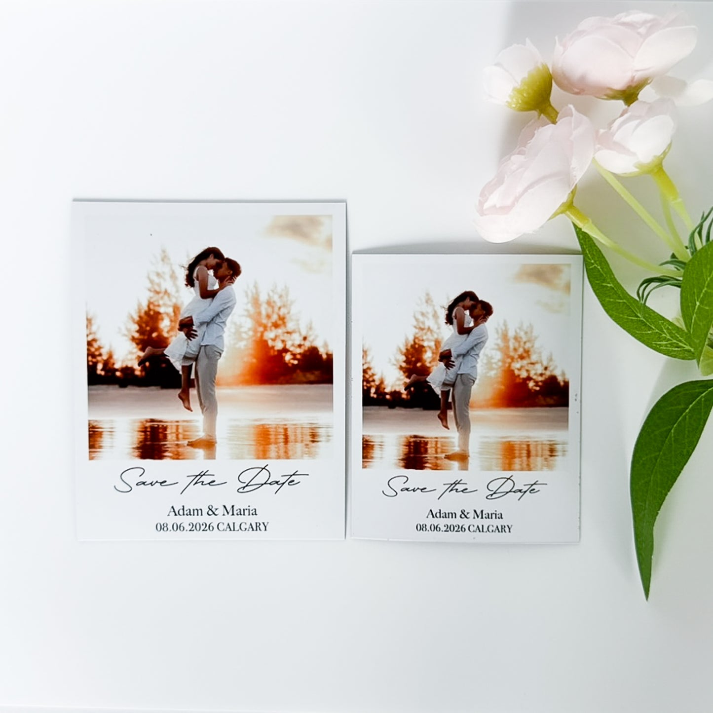 Two 'Save the Date' photo magnets with a couple by a lake, accompanied by a bouquet of flowers.