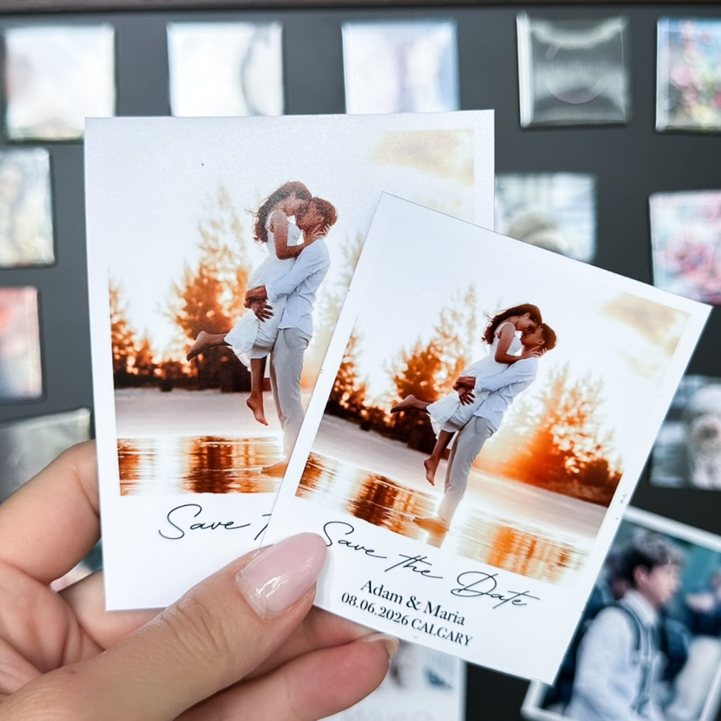 Two 'Save the Date' photo magnets held by a hand with a blurred background
