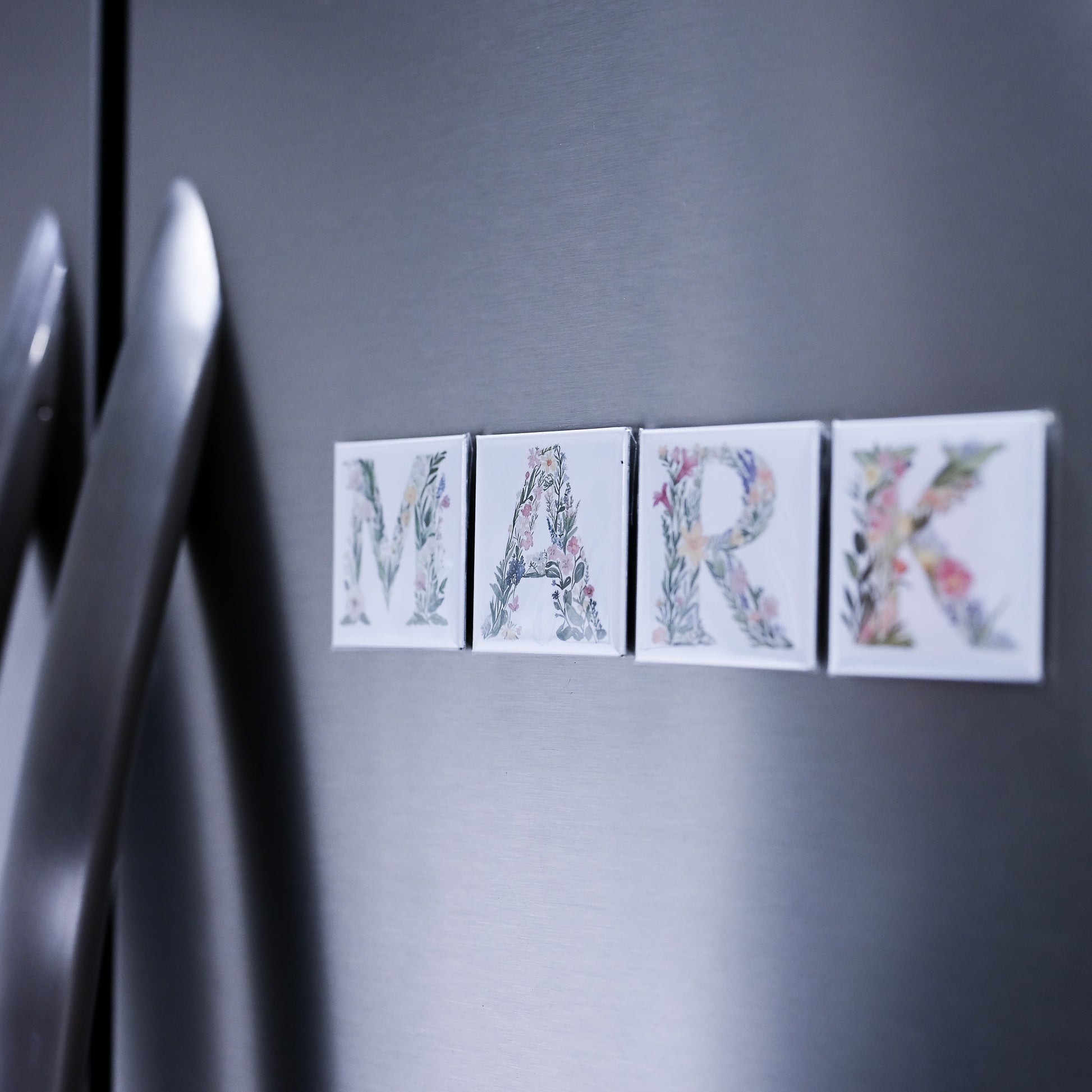 Decorative name magnets spelling 'MARK' on a refrigerator door.