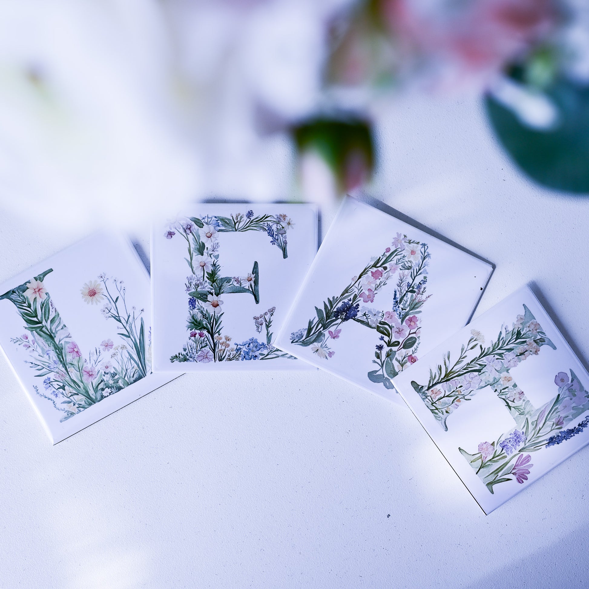 Floral alphabet magnets spelling 'Leah' on a white surface with blurred background