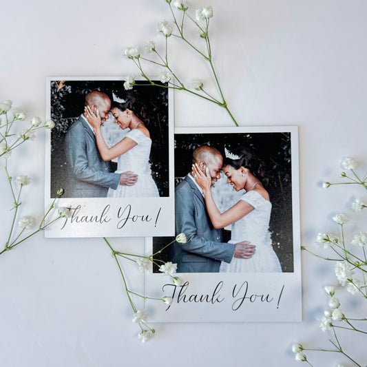 Two Photo Magnets with 'Thank You!' text, surrounded by white flowers on a light background.