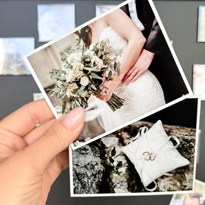 Hand holding a photo magnets of a wedding bouquet, rings, and a couple's hands.