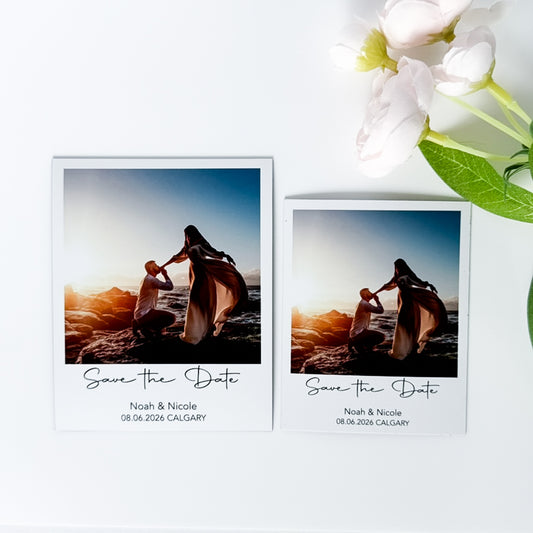 Two 'Save the Date' photo magnets with a couple on a beach at sunset, featuring white flowers.