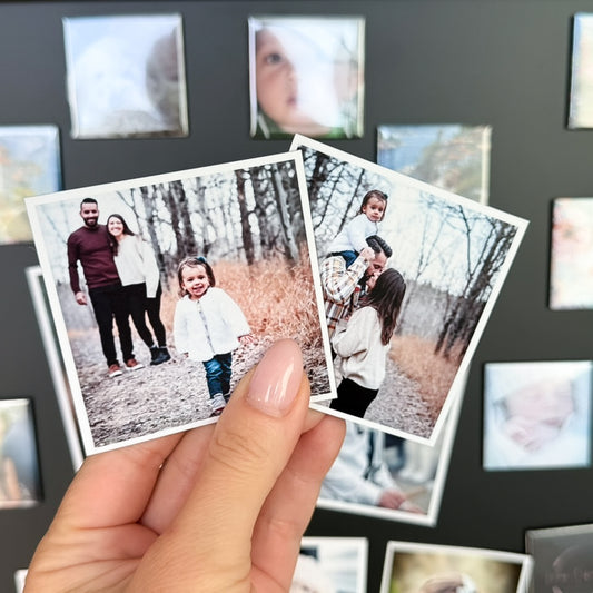 Two small photo magnets held in front of a board with more photo magnets.